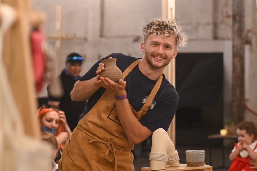 Photo of Sam holding a ceramic vessel
